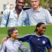 A photo of three Chelsea legends — Michael Essien, Jose Mourinho, and Didier Drogba — standing together during their time at Chelsea. Mourinho is in a suit, while Essien and Drogba wear Chelsea training kit. All three are smiling, celebrating a victory.